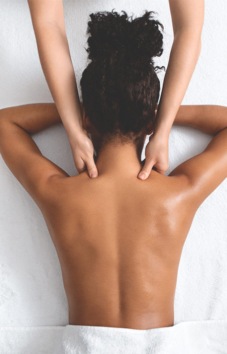 A woman receives a massage at the spa by her trusted spa therapist as part of her wellness practices.